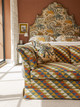 Sofa upholstered in Busy Lizzie Indoor Woven fabric in Olive by Kit Kemp Design Studio, showcasing a blend of olive, teal, and terracotta tones in a Moroccan-inspired bedroom at Firmdale Hotel.